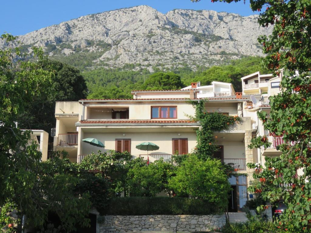ein Gebäude mit einem Berg im Hintergrund in der Unterkunft Guest House Mijo Sokol in Brela