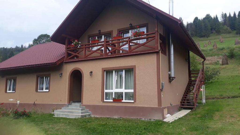 a small house with a balcony on top of it at Садиба у Насті in Nizhniy Studenyy