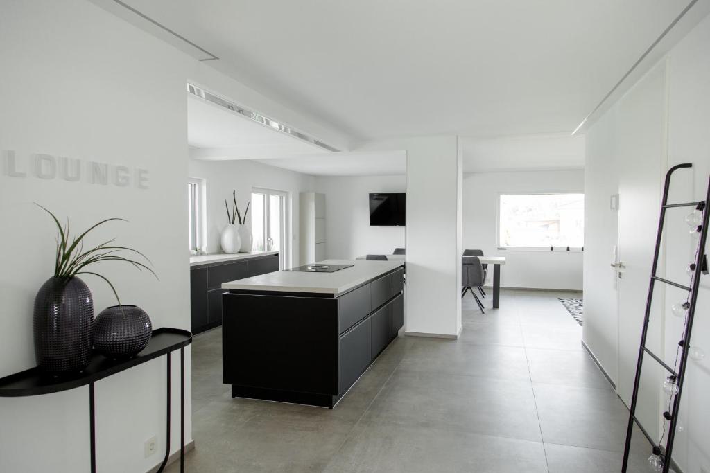 a white kitchen with a black island in a room at Einzigartiges Loft von Loftalive in Lollar