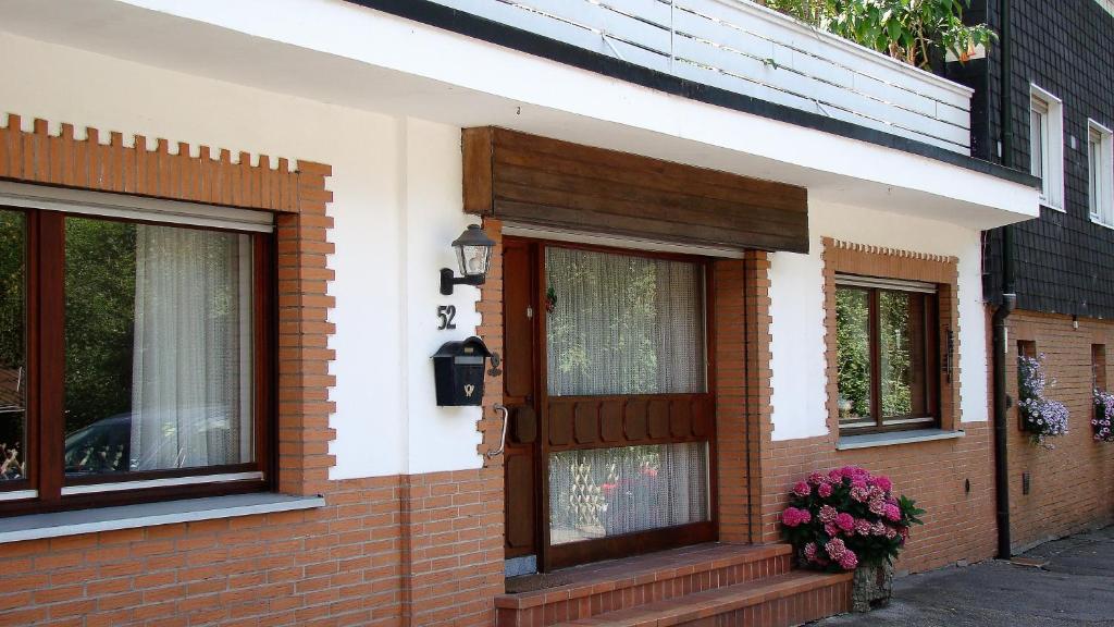 uma casa de tijolos com uma porta de madeira e janelas em Ferienwohnung Heidi em Altena