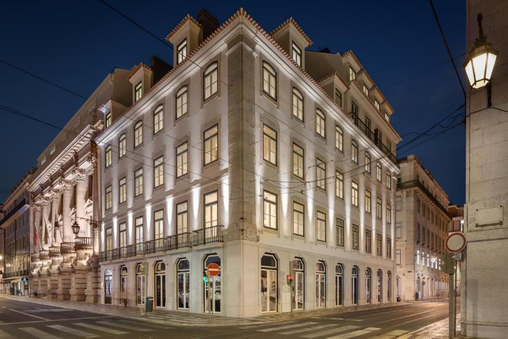 a large white building on a street at night at Residentas Aurea in Lisbon