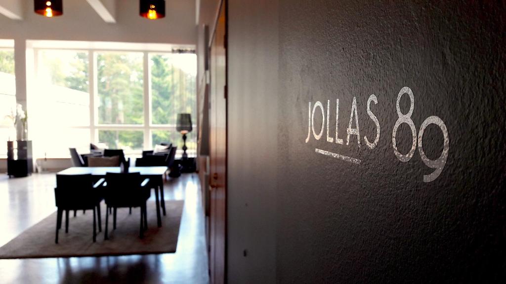 a dining room with tables and chairs and a sign on the wall at Hotel Jollas89 in Helsinki