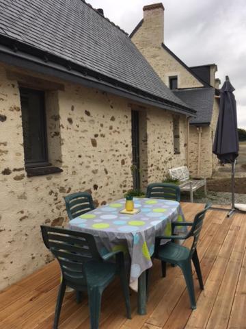 a table and chairs sitting on a wooden deck at Le petit paradis in Daumeray