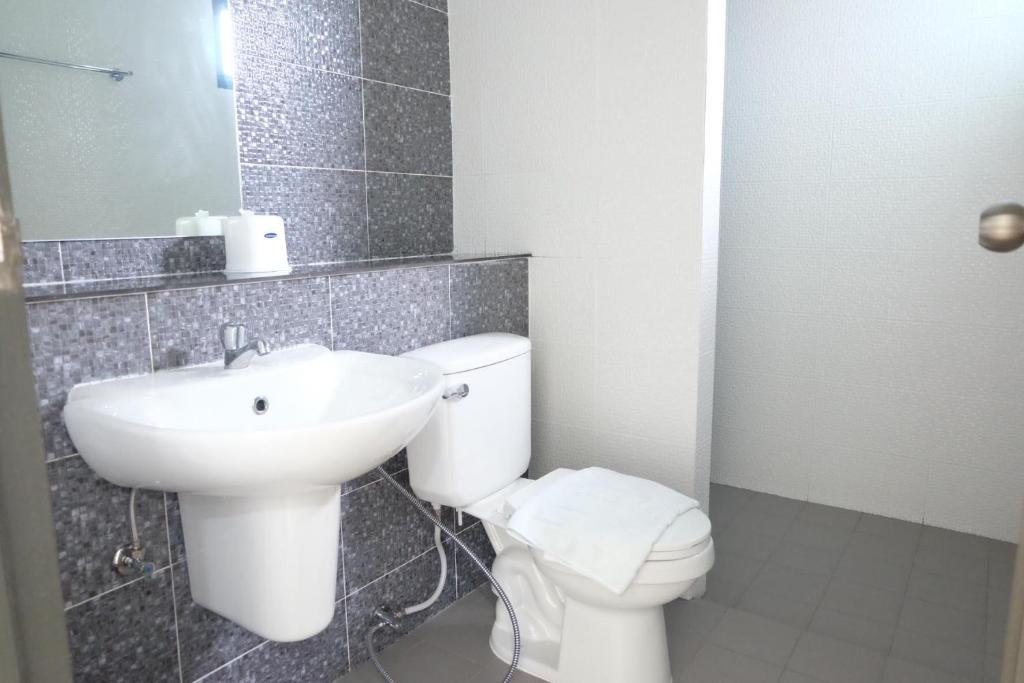 ナイヤンビーチにあるDOS'S HOUSEの白いトイレと洗面台のあるバスルーム