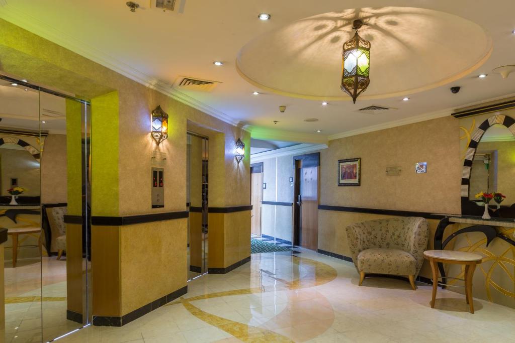 a lobby with a chair and a ceiling at THE PARK HOTEL Formerly Al Jawhara Gardens in Dubai