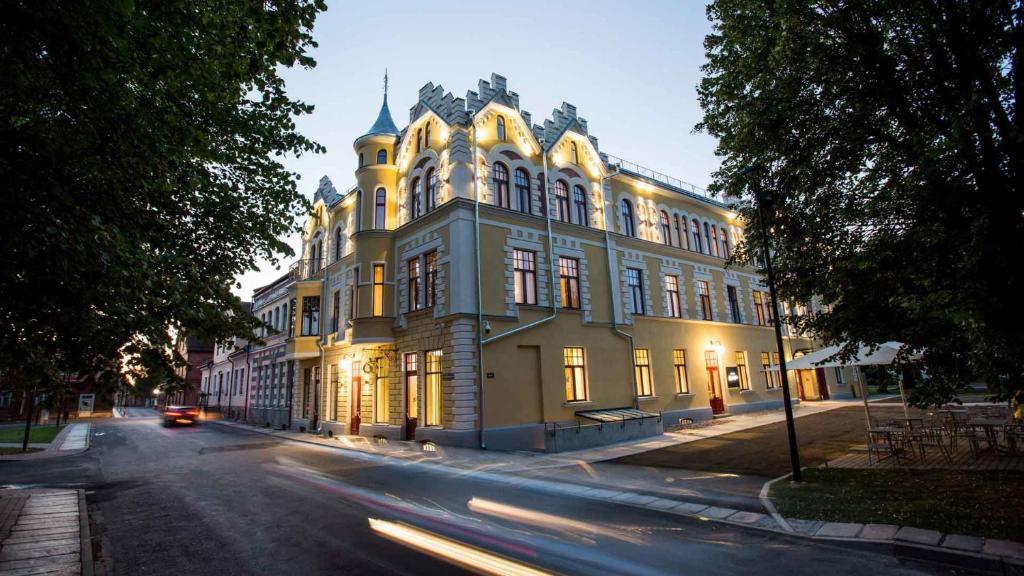 a building on a street with a car driving past it at Park Hotel Viljandi in Viljandi