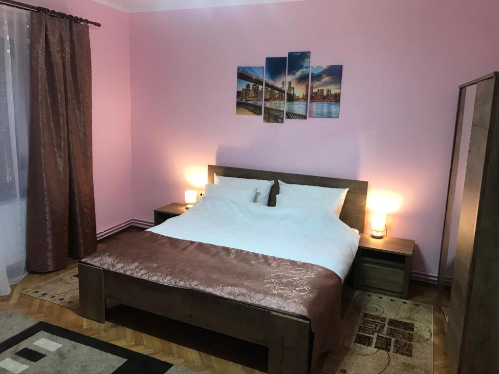 a bedroom with a large bed with two lamps on tables at Casa TRANSILVANIA in Oradea