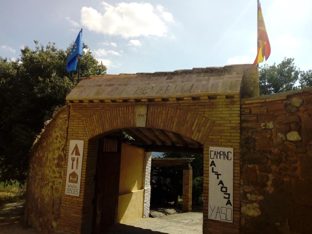 un bâtiment en briques avec deux drapeaux au-dessus dans l'établissement Guara-Altaoja-Yaso, à Yaso