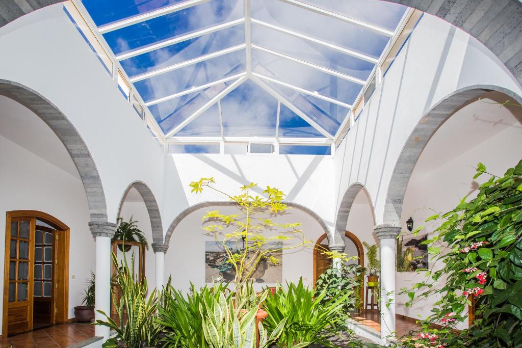 an indoor greenhouse with a glass ceiling and plants at Finca de la Geria in Yaiza