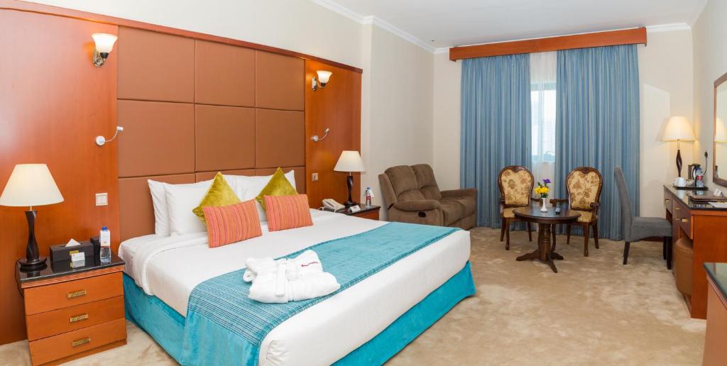 a hotel room with a large bed and a desk at THE PARK HOTEL Formerly Al Jawhara Gardens in Dubai