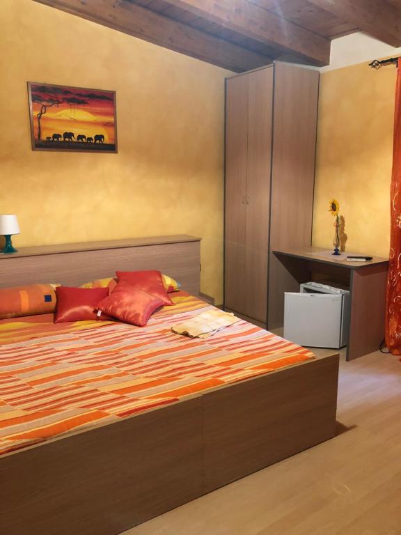 um quarto com uma cama grande e um cobertor laranja em B&B Melius em Migliuso