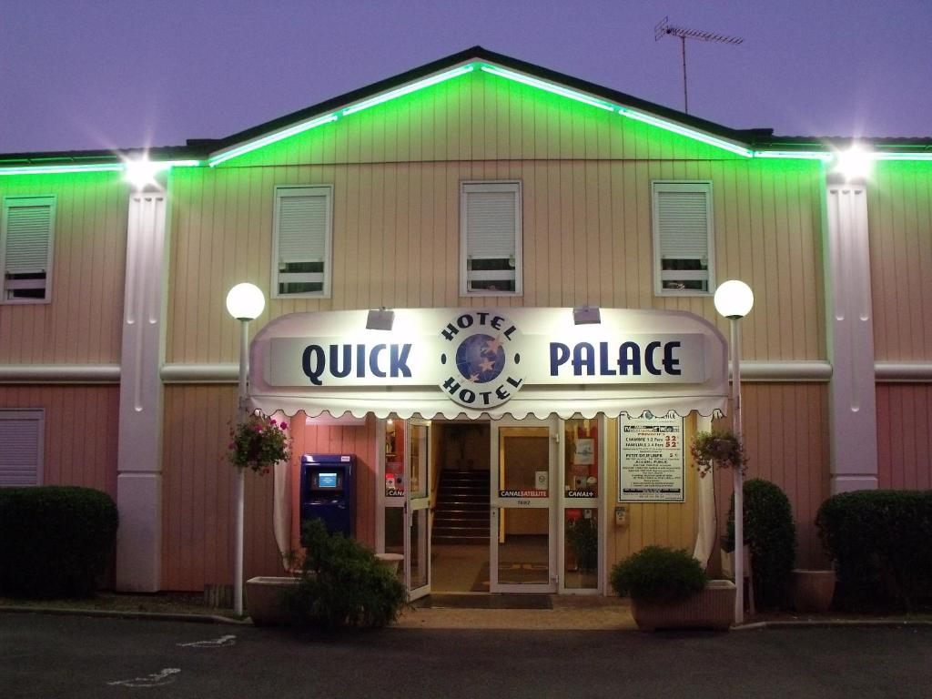 een quik- en paleisgebouw 's nachts met groene lichten bij Quick Palace Auxerre in Monéteau