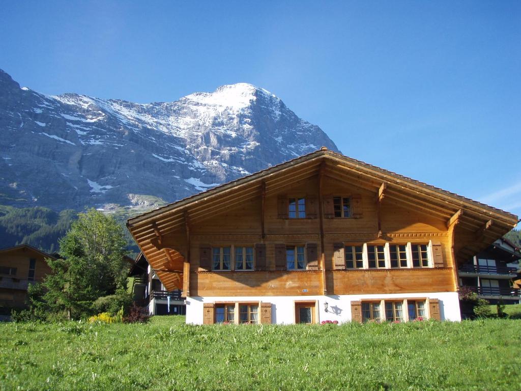 グリンデルワルトにあるChalet Asterixの山を背景にした大きな木造建築