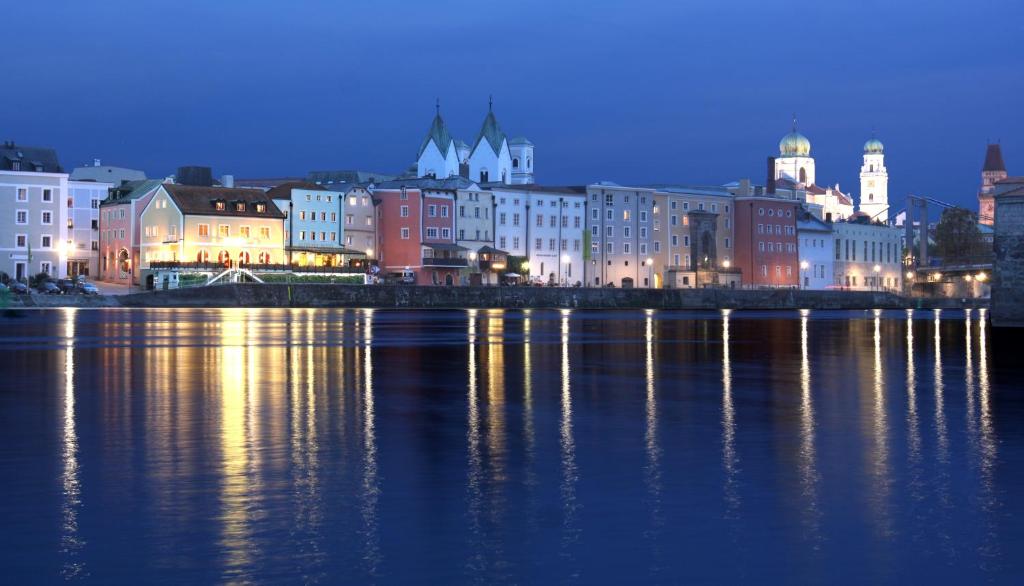 a city at night with the lights on the water w obiekcie Altstadt-Hotel Passau w Pasawie