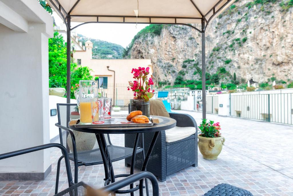 una mesa con bebidas y naranjas en el patio en Nonna Enza Apartment, en Atrani