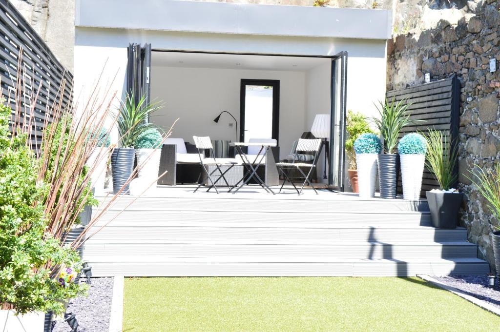 a patio with white stairs and a table and chairs at Pier39Portrush Adult Only in Portrush