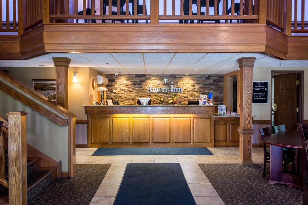 ein Restaurant mit einer Bar in der Mitte eines Zimmers in der Unterkunft AmericInn by Wyndham Green Bay West in Green Bay
