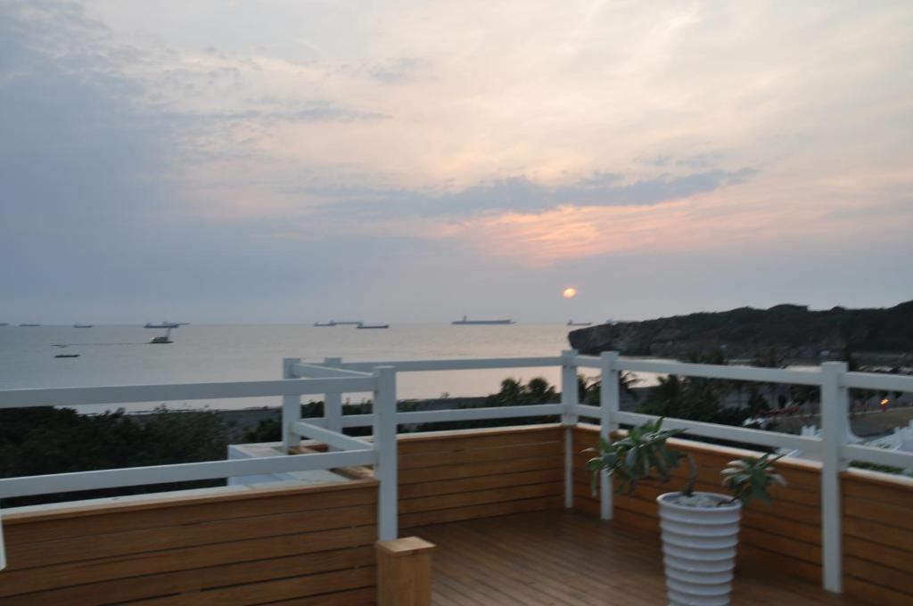 a balcony with a view of the ocean at sunset at In Young Hotel in Kaohsiung