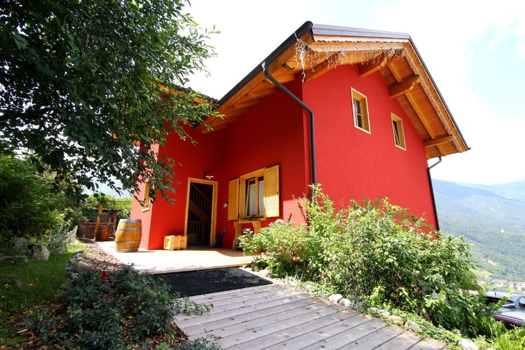 uma casa vermelha com um caminho à sua frente em Activity Appartamento Vacanze em Spormaggiore