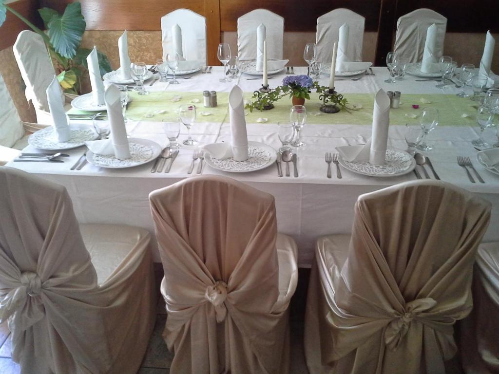 un tavolo con tovaglie e sedie bianche a un matrimonio di Gostišče - Guest house STARI HRAST a Ljutomer