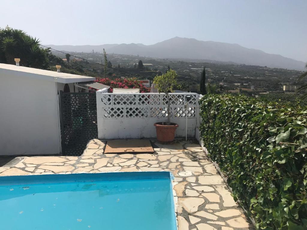 a swimming pool in a yard with a white fence at Casitas Las Pereras in Los Llanos de Aridane