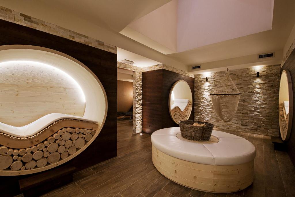 a bathroom with a round tub and a circular mirror at La Torretta in Passo del Tonale