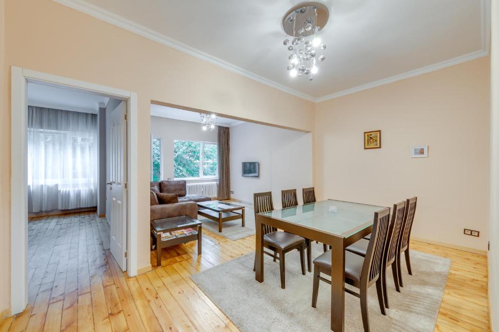 uma sala de jantar e sala de estar com mesa e cadeiras em Central Apartment em Sófia