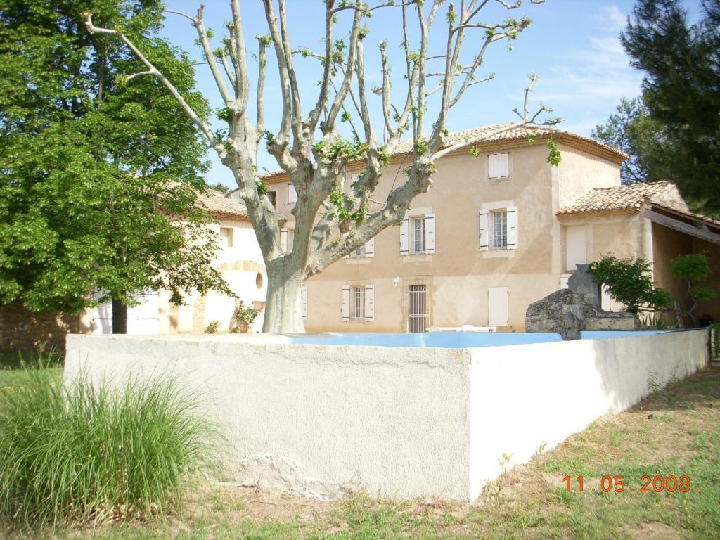 a large house behind a concrete wall at MAS PROVENCAL LE ROCAn in Aubignan