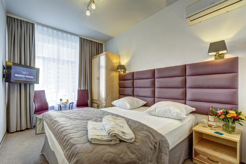 a hotel room with a large bed with towels on it at Wellion Vodniy in Moscow