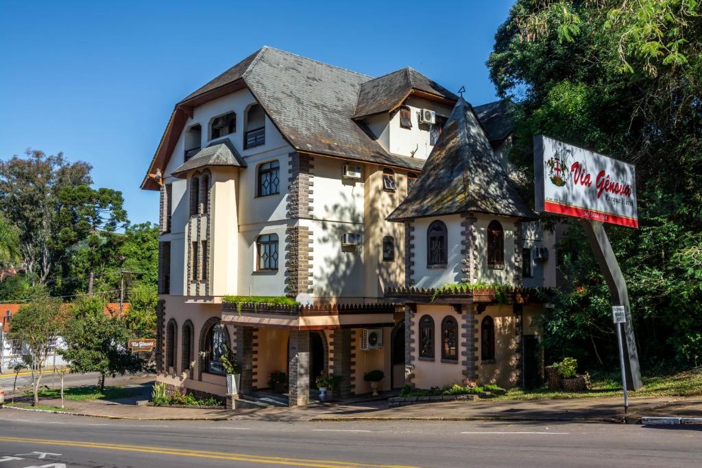 een oud huis op de hoek van een straat bij Via Genova Parque Hotel in Serafina Corêa