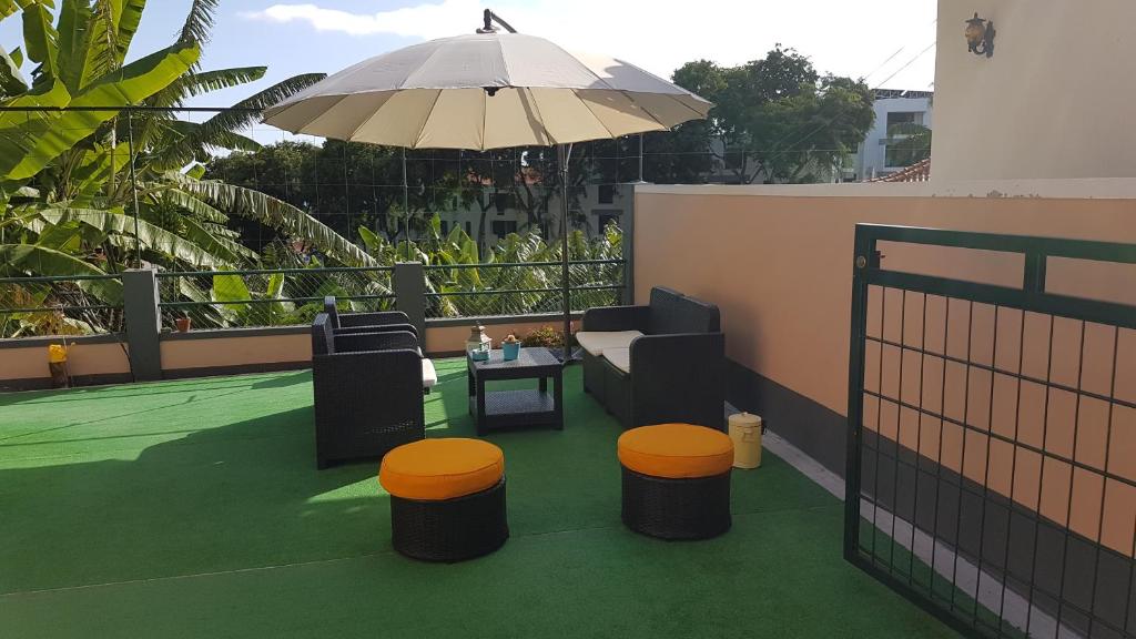 a patio with an umbrella and a table and chairs at FX Pena in Funchal
