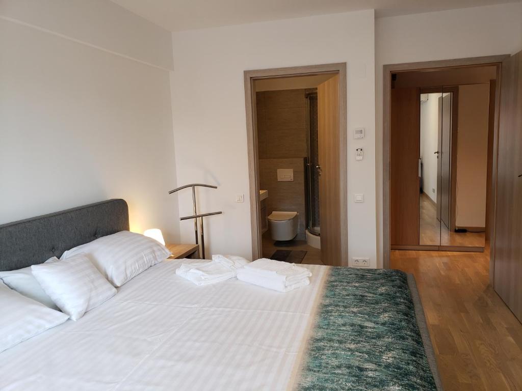 1 dormitorio con 1 cama con 2 toallas en Urban Nest Apartment en Bucarest
