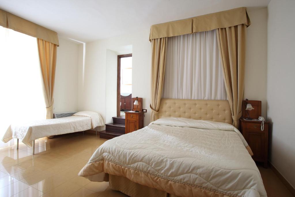 Postel nebo postele na pokoji v ubytování Hotel Roma