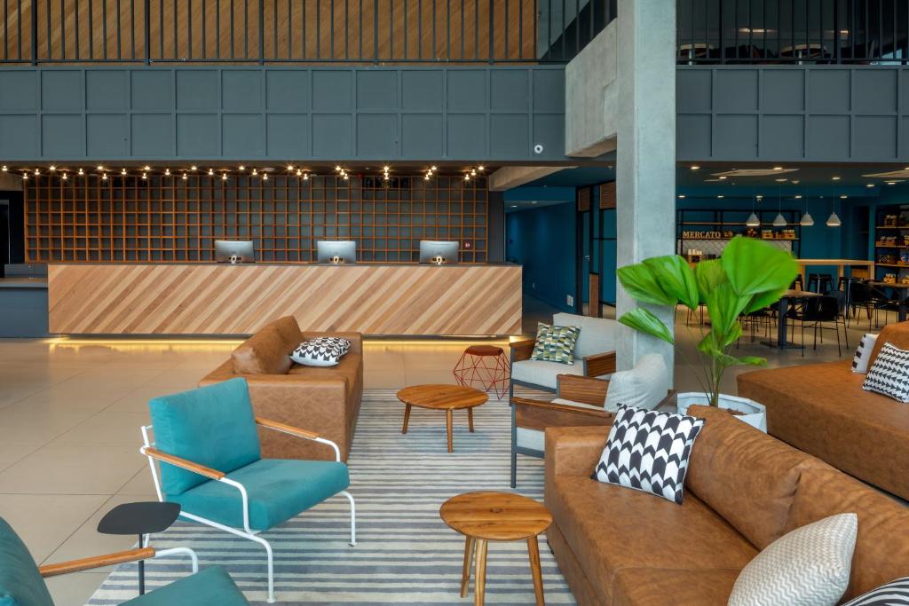 a lobby with couches and chairs and a bar at Linx Galeão in Rio de Janeiro