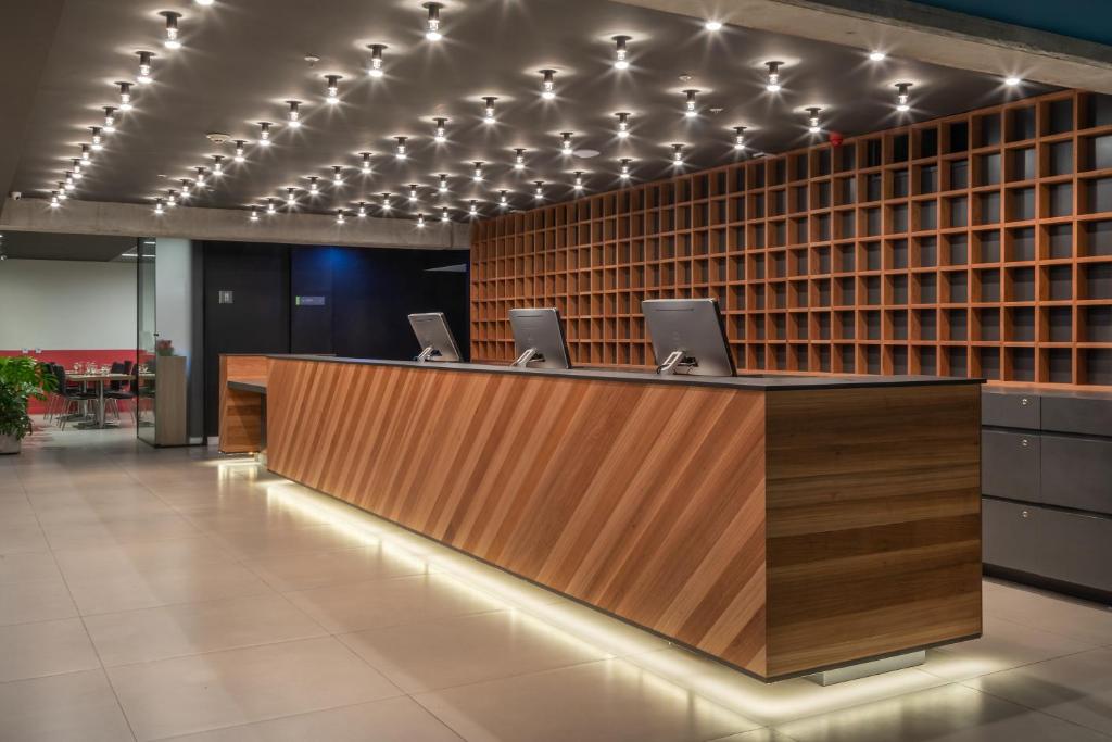 an office lobby with a desk with laptops on it at Linx Galeão in Rio de Janeiro