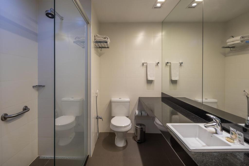 a bathroom with a toilet, sink, and shower at Linx Galeão in Rio de Janeiro