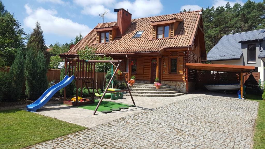 a house with a slide and a playground at Mazury Drewniany Dom Malkinie k/Ełku in Małkinie