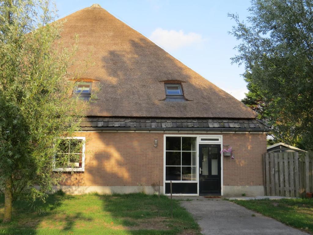 ein altes Backsteinhaus mit Strohdach in der Unterkunft appartement het Stolpje in Julianadorp