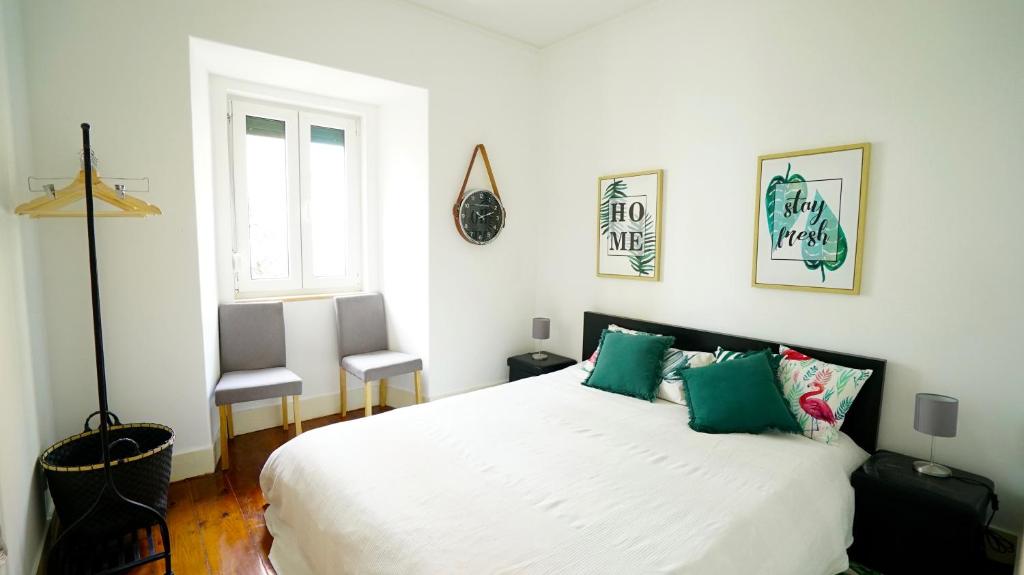 リスボンにあるCatchy @ Campo Pequenoのベッドルーム(緑の枕が付く大きな白いベッド付)