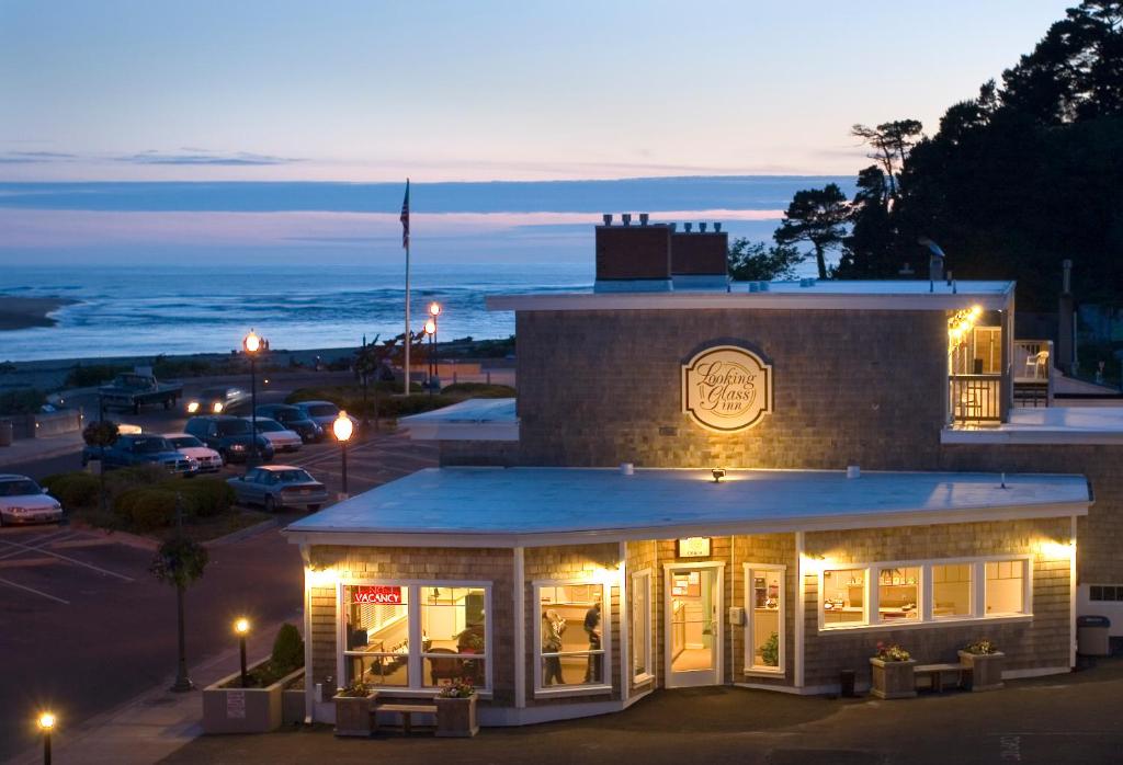 a restaurant with a view of the ocean at night at Looking Glass Inn in Lincoln City