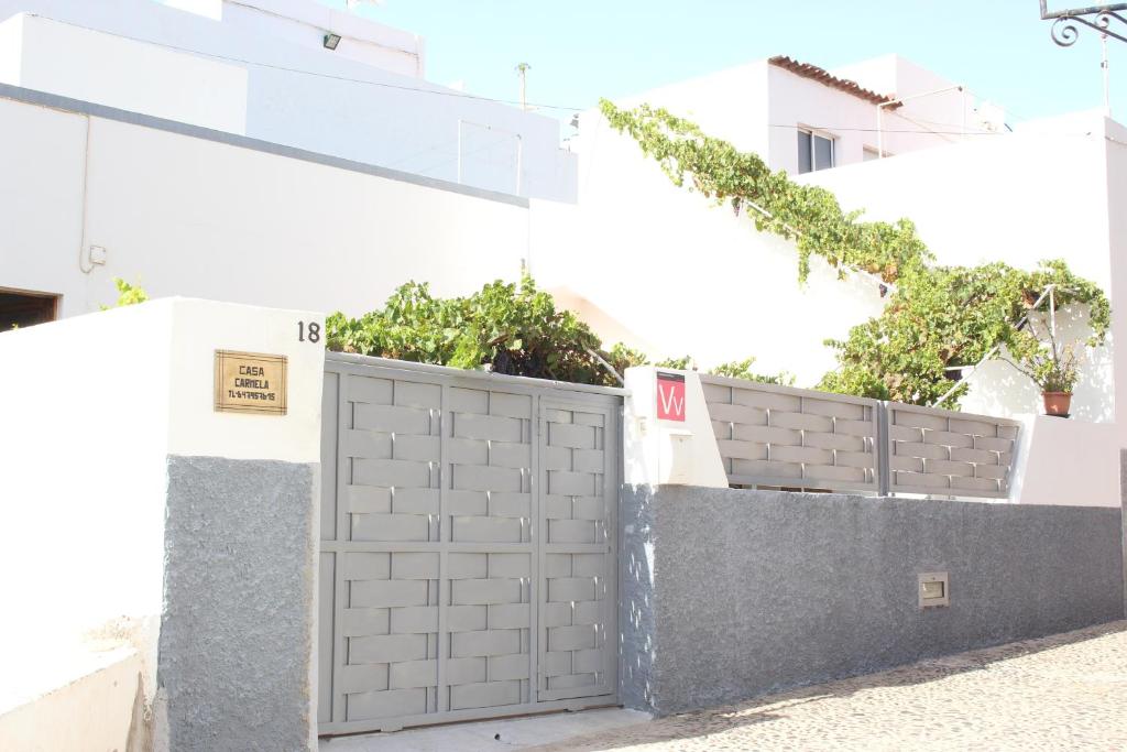 una valla gris con una puerta delante de un edificio en Casa Carmela, en Agaete
