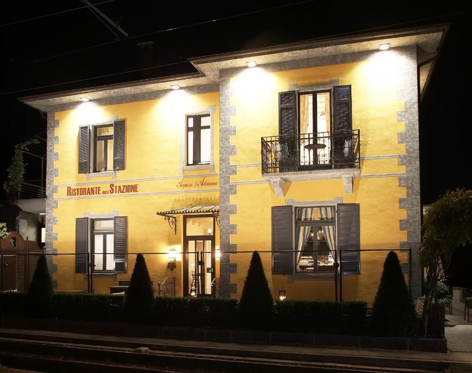 a yellow building with a balcony and lights on it at Ristorante Stazione da Agnese & Adriana in Intragna