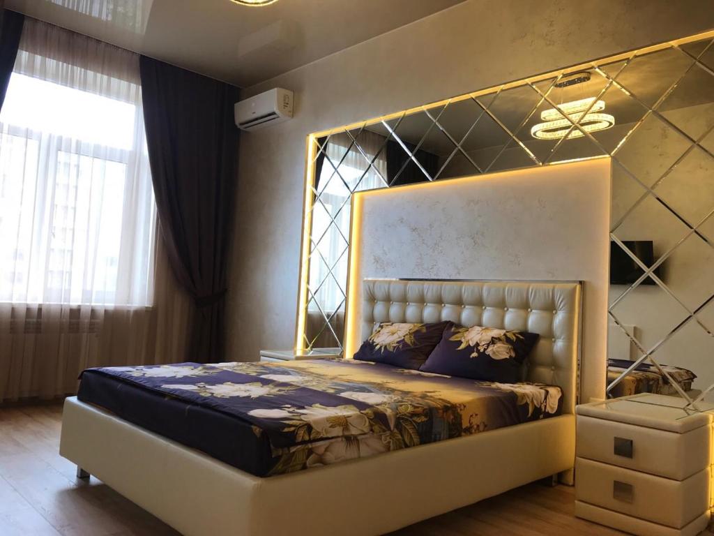 una camera da letto con un grande letto con telaio dorato di Luxury Apartment in Downtown, Near River Esplanade a Charkiv