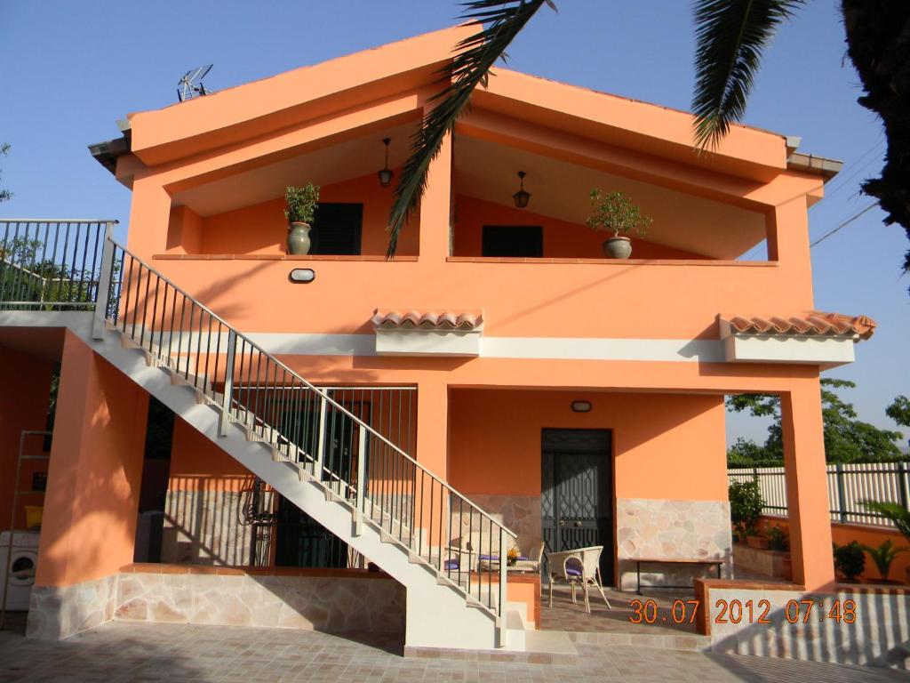 ein orangenes Haus mit Treppe davor in der Unterkunft Casa Concetta in Noto Marina