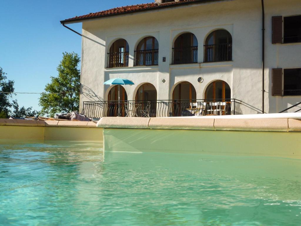 una casa con una piscina d'acqua accanto a un edificio di Villa Cadenza a Murazzano
