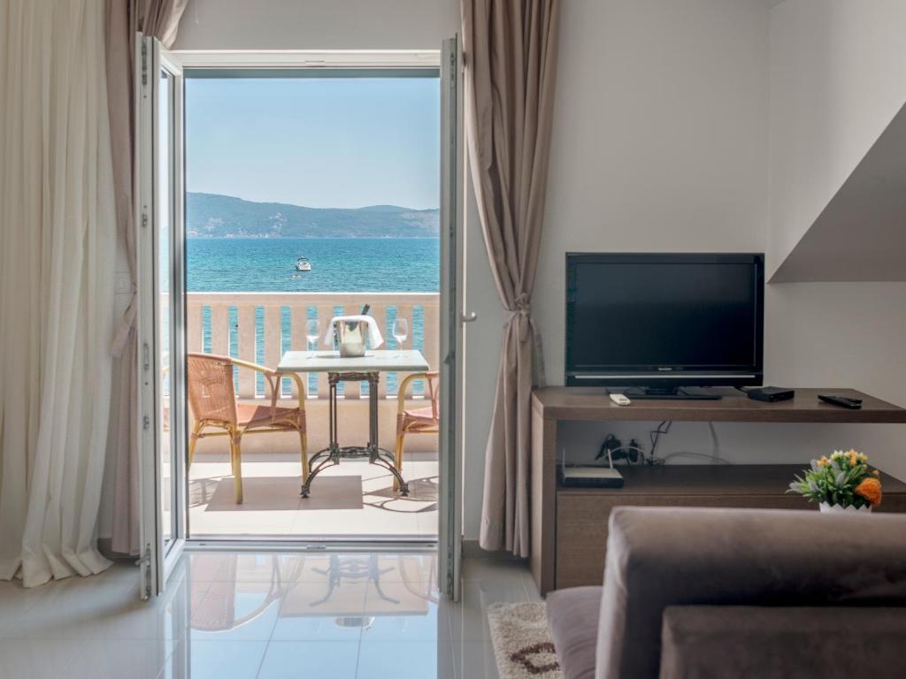 d'un salon avec une porte coulissante en verre menant à une terrasse. dans l'établissement Grifone Coastline, à Herceg-Novi