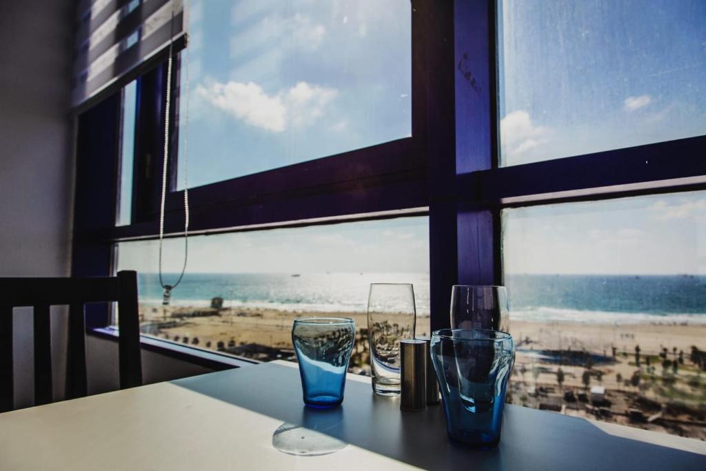 two glasses on a table with a view of the beach at Ashdod Beach Hotel in Ashdod
