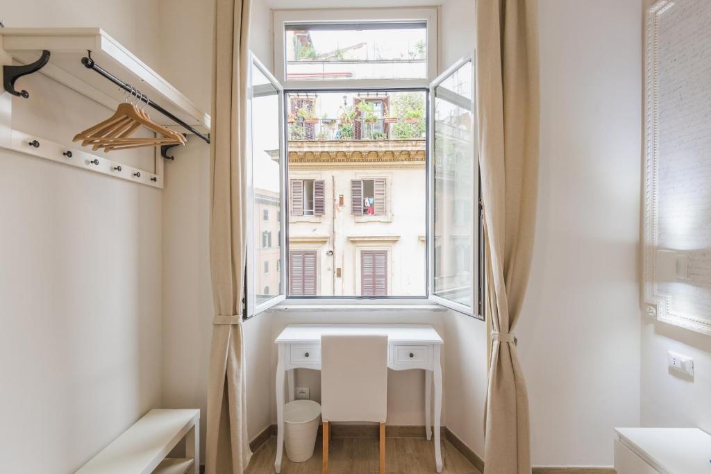 ローマにあるWalker Roomsの窓付きの小さなバスルーム、白いデスクが備わります。