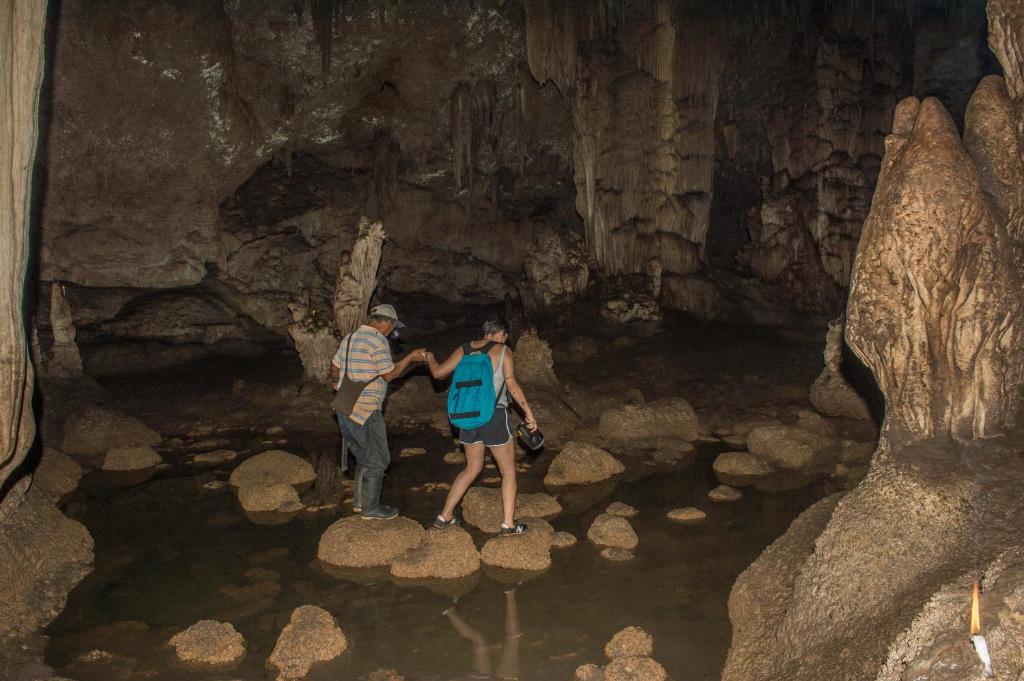 three people standing on rocks in a cave at Finca Ixobel in Ixobel