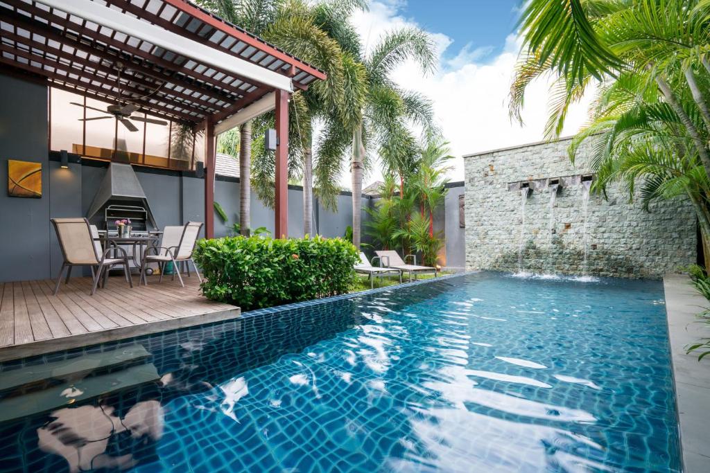 a pool with a table and chairs next to a house at Two bedrooms pool villa at Saiyuan estate in Rawai Beach